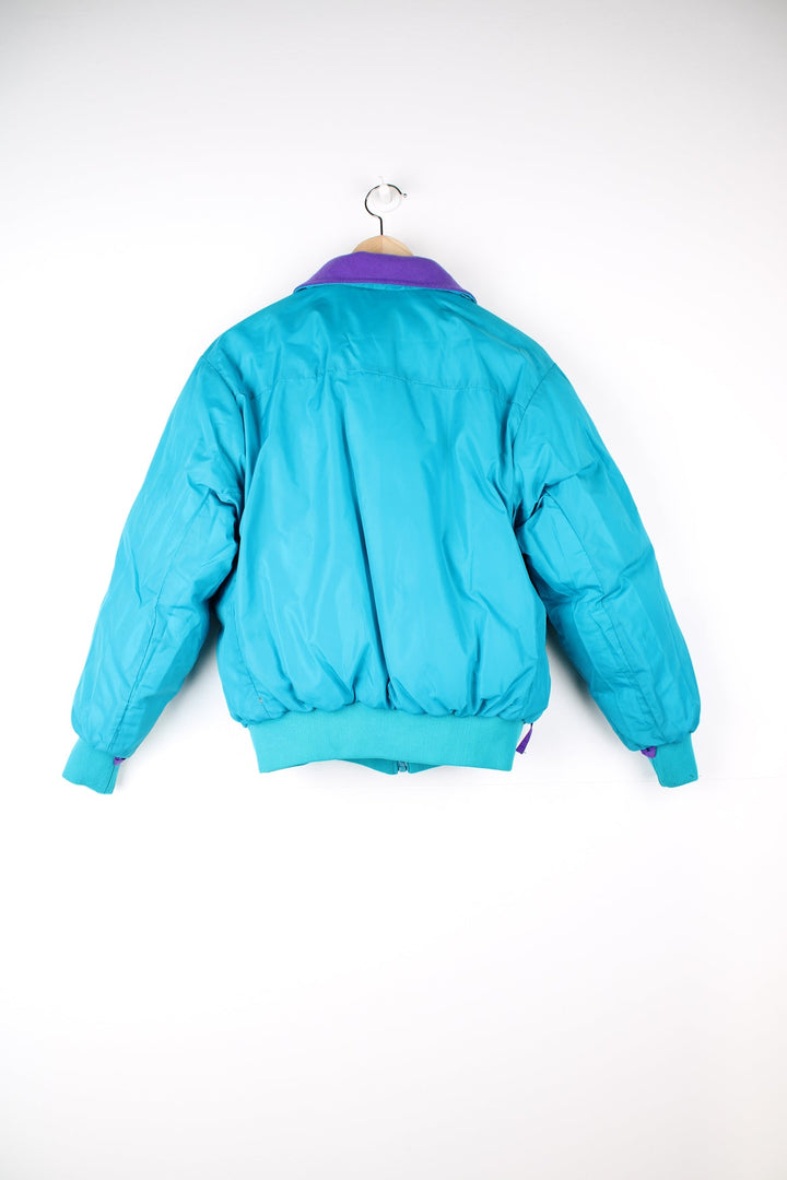 Vintage Columbia reversible puffer jacket in purple and green. Features puff print logo on the chest.