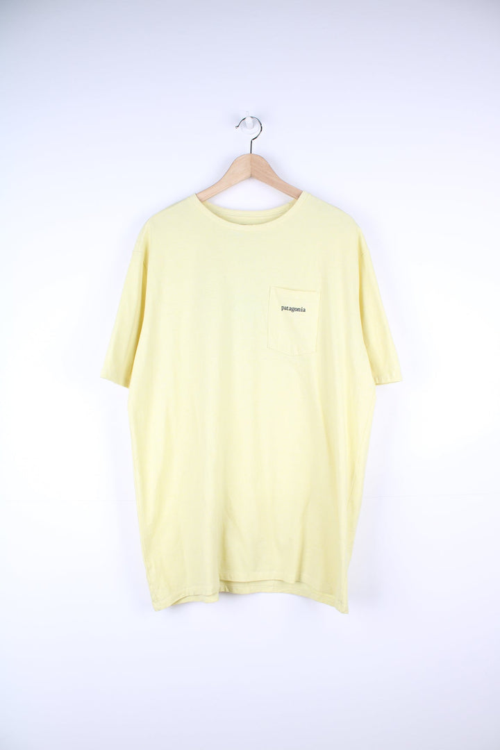 Yellow Patagonia T-Shirt with printed logo and pocket on the chest, and graphic print on the back.