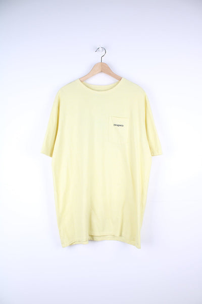 Yellow Patagonia T-Shirt with printed logo and pocket on the chest, and graphic print on the back.