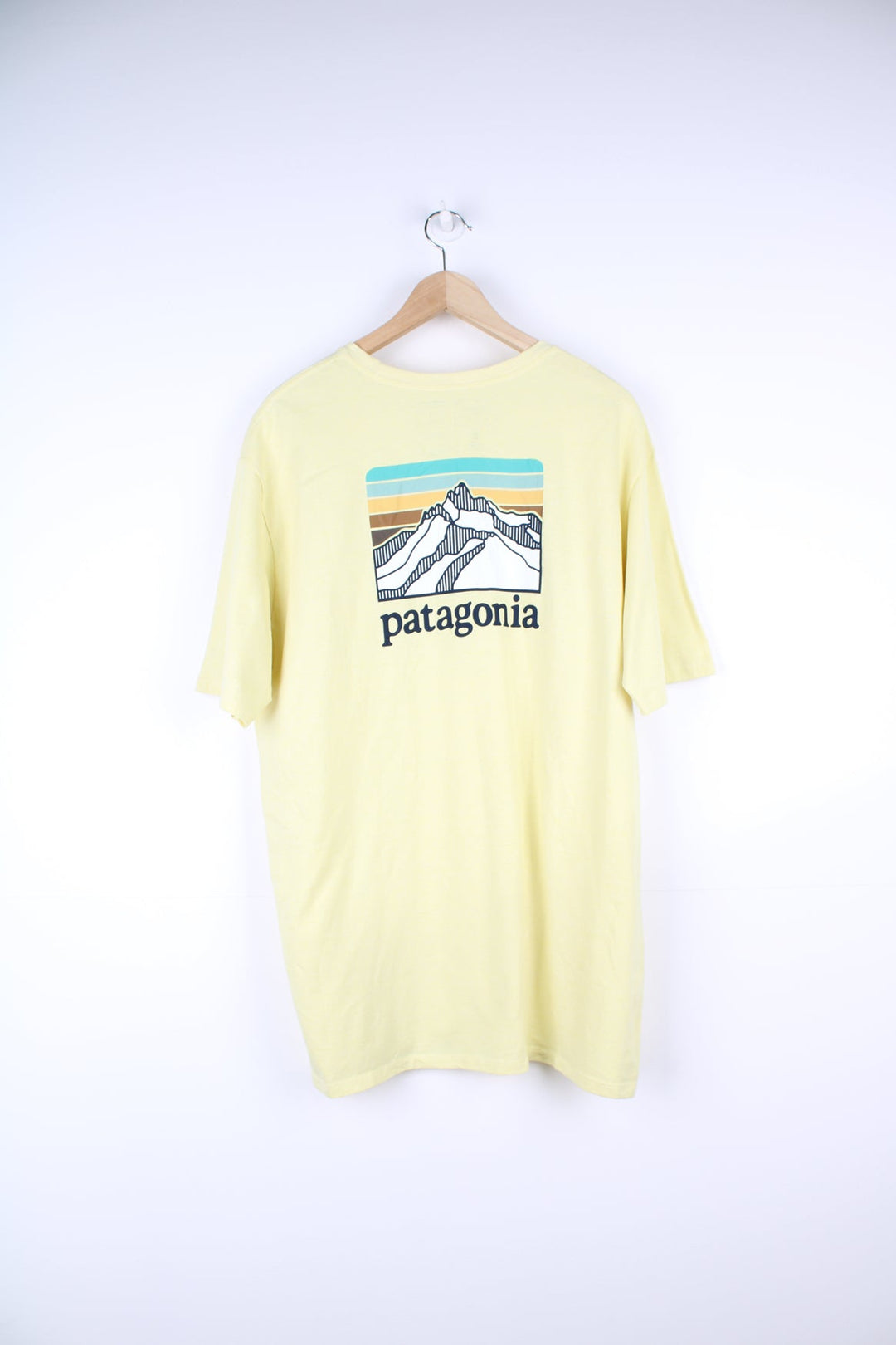 Yellow Patagonia T-Shirt with printed logo and pocket on the chest, and graphic print on the back.