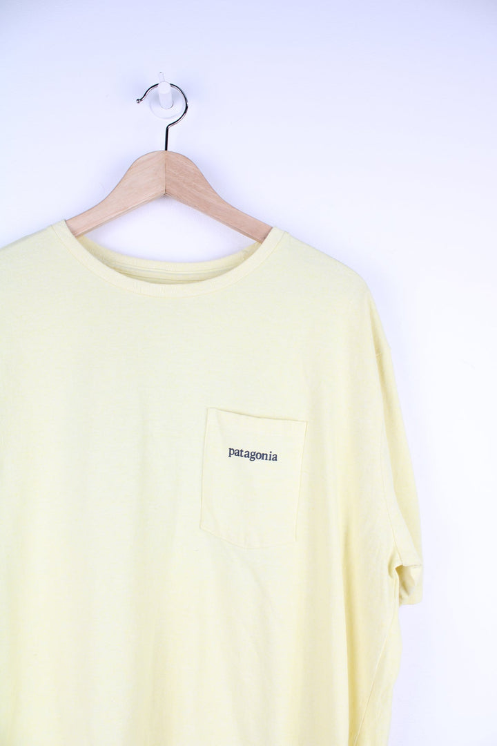 Yellow Patagonia T-Shirt with printed logo and pocket on the chest, and graphic print on the back.