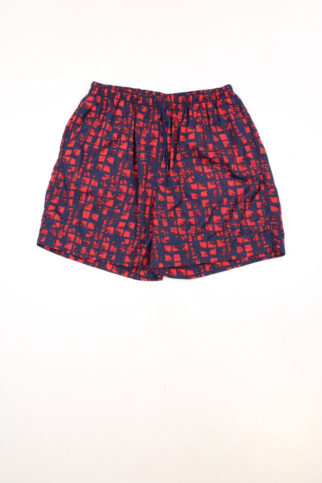 Nike Patterened Shorts in a red and navy blue colourway, has an elasticated waist with drawstring, side pockets, and the swoosh logo embroidered on the front. 