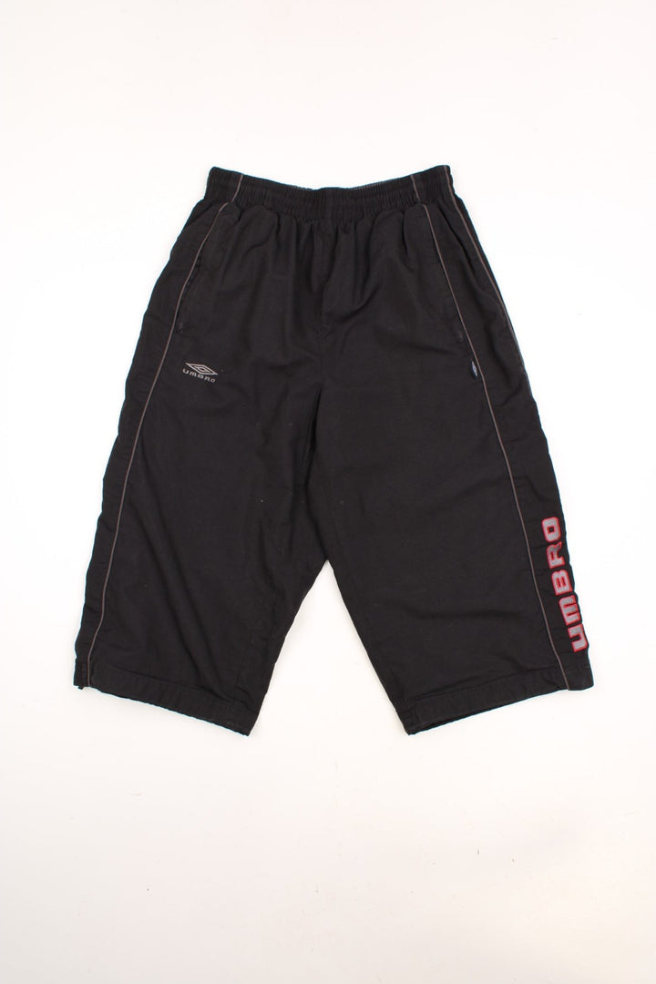 Umbro 3/4 Length Shorts in a black colourway, has an elasticated waist with drawstrings, side pockets, and the logo embroidered on the front and going down the left side. 