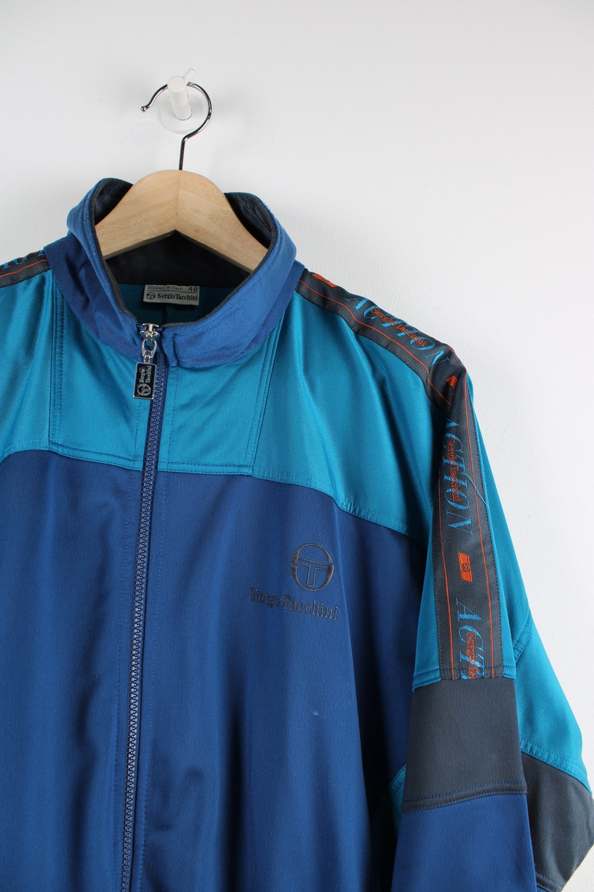 Vintage blue Sergio Tacchini tracksuit top featuring embroidered logo, blue panels and branded stripes down each arm.