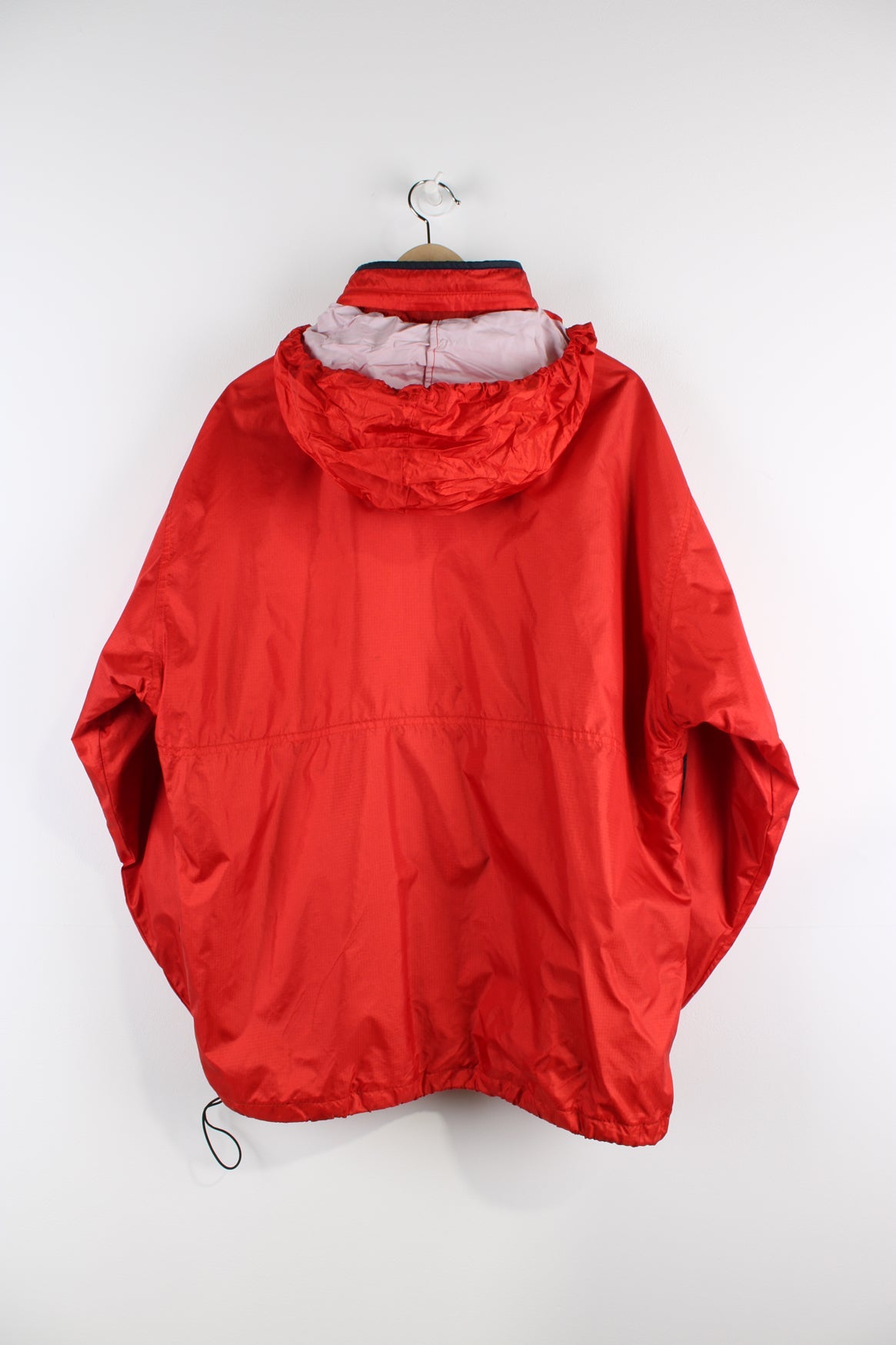 Vintage Reebok red pullover jacket with half zip, embroidered logo, packaway hood and large central pocket.