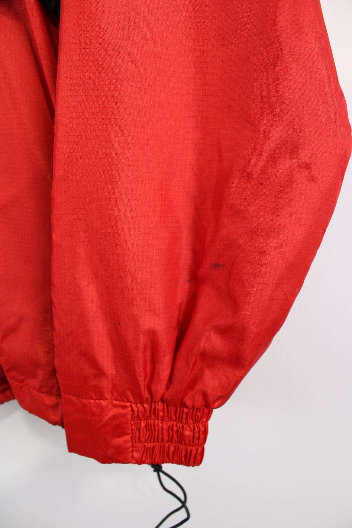 Vintage Reebok red pullover jacket with half zip, embroidered logo, packaway hood and large central pocket.