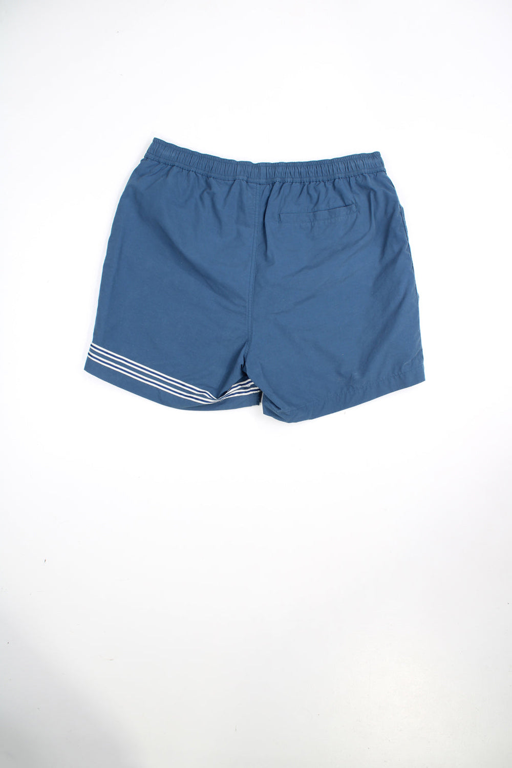 Blue Timberland swim shorts with elasticated waist and drawstring. Features embroidered logo and stripe detail.