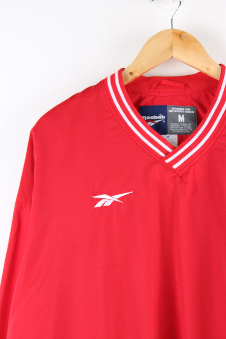 Red Reebok drill top with embroidered logo on the chest.