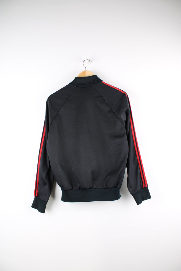 Vintage 80s Adidas tracksuit top in black with red and green stripes. Features embroidered logo on the chest.