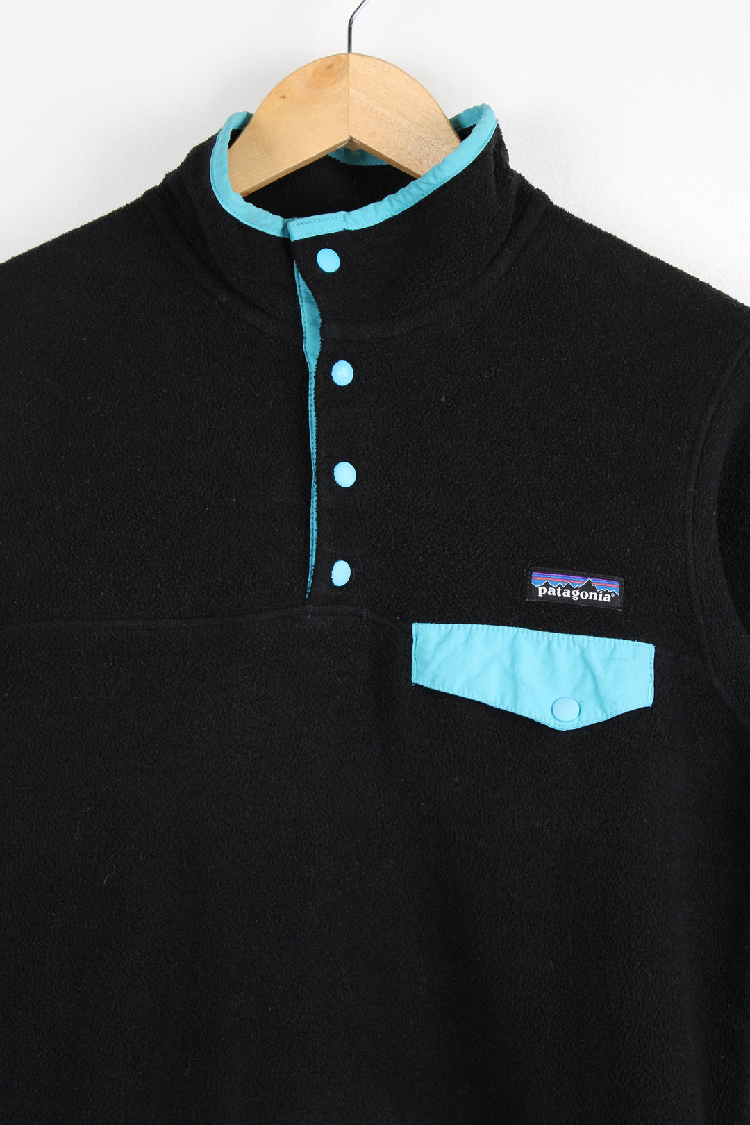 Patagonia Synchilla fleece in black features snap t closure and embroidered logo on the chest