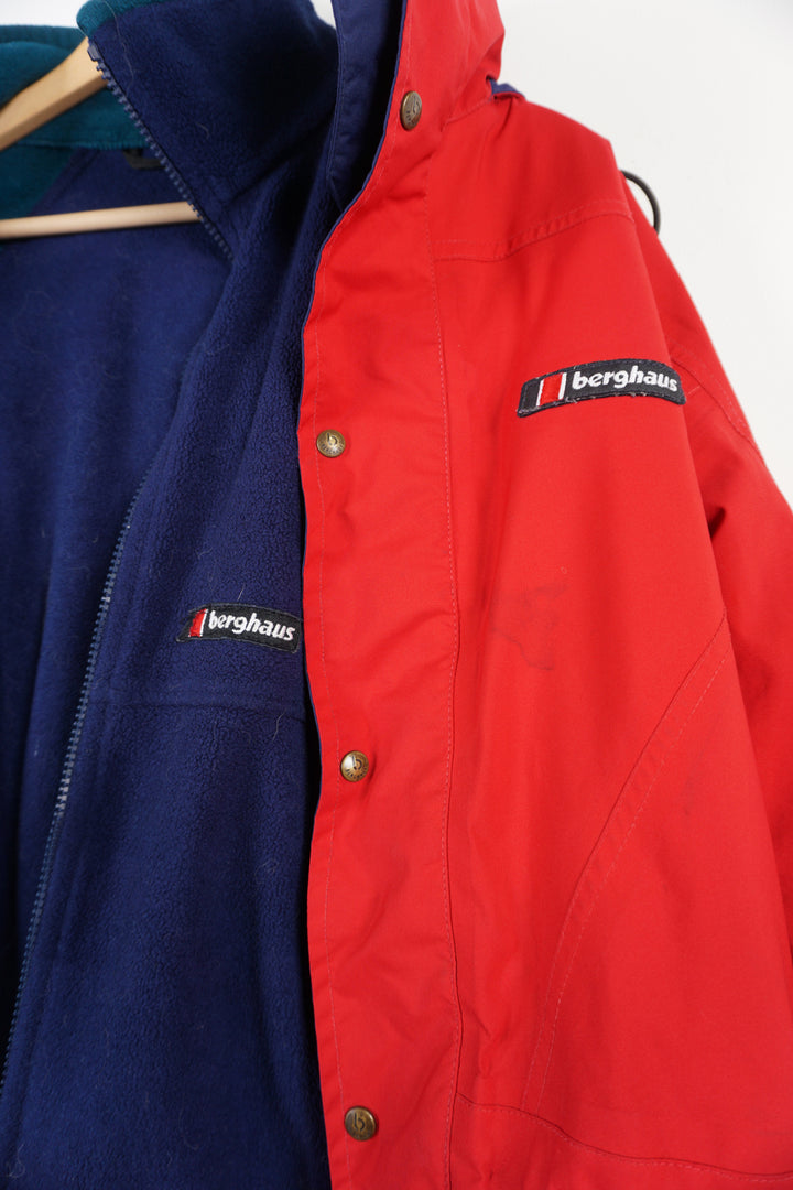 Berghaus red zip through waterproof jacket with removable fleece lining and draw string waist, embroidered logo on the chest and foldaway hood