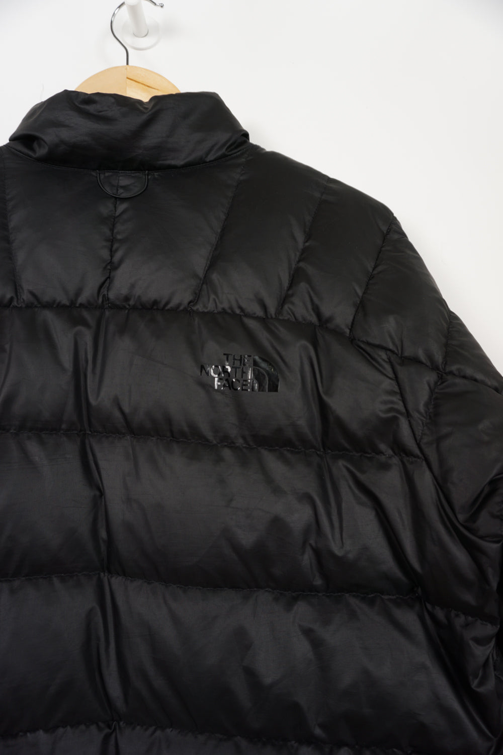 All black The North Face shine logo puffer jacket with double pockets and drawstring hem