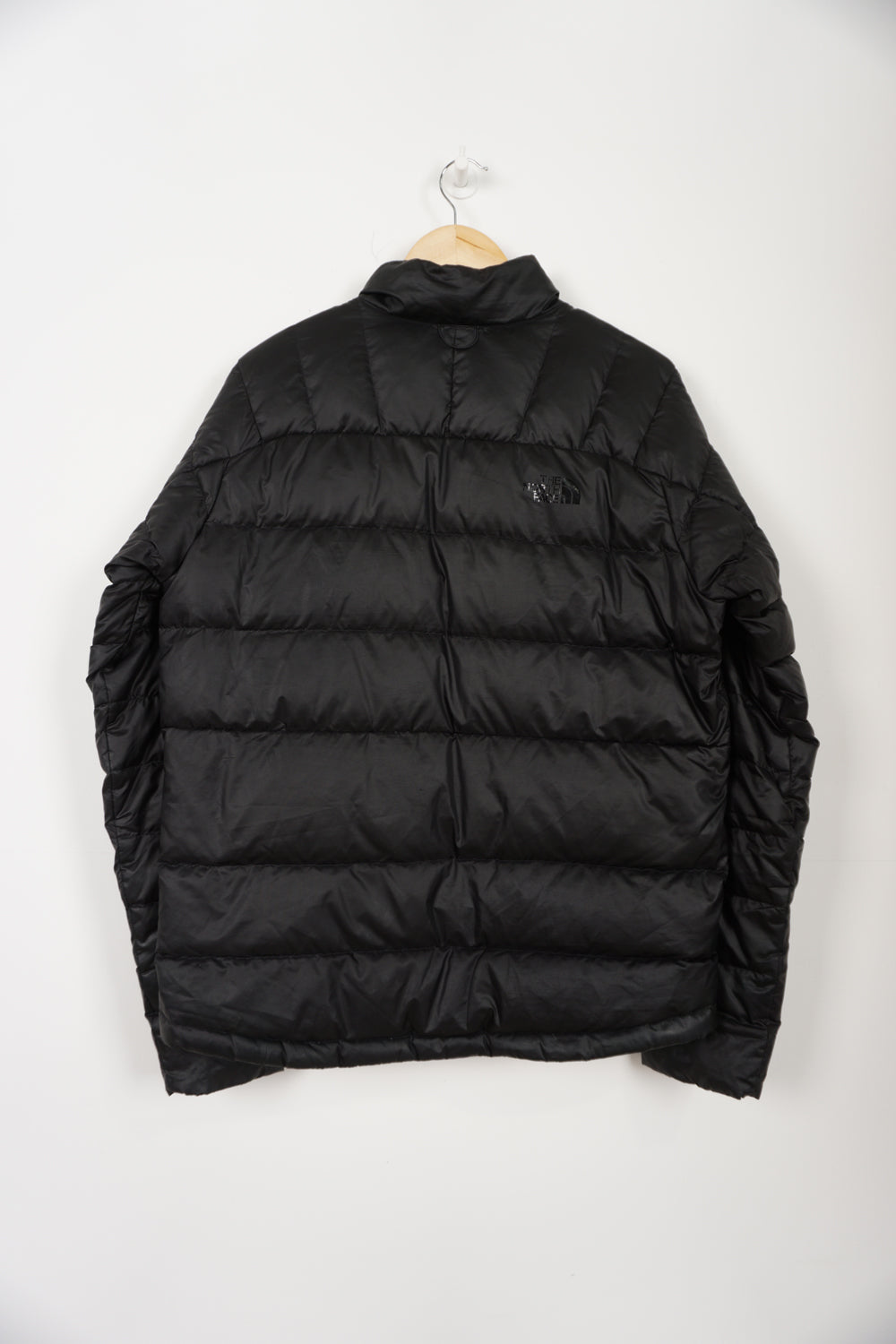 All black The North Face shine logo puffer jacket with double pockets and drawstring hem