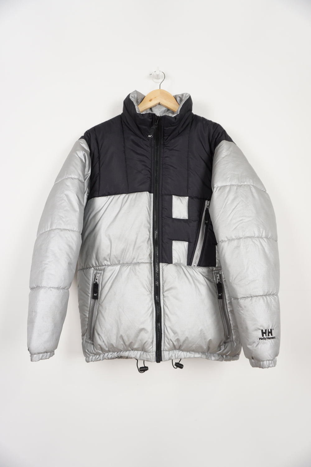 Silver and black Helly Hansen puffer jacket with multiple pockets, drawstring hem and embroidered spell-out logos on front and back