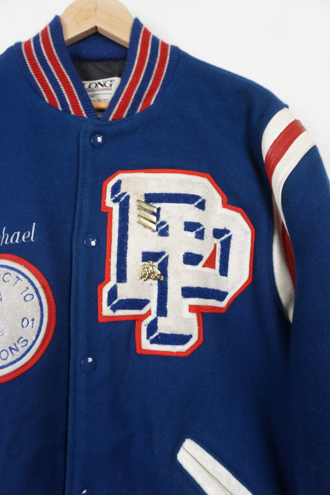 Vintage Patriots Wrestling wool varsity jacket in blue. Features embroidered details and wrestling themed pins 