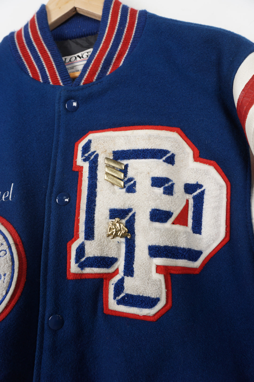 Vintage Patriots Wrestling wool varsity jacket in blue. Features embroidered details and wrestling themed pins 