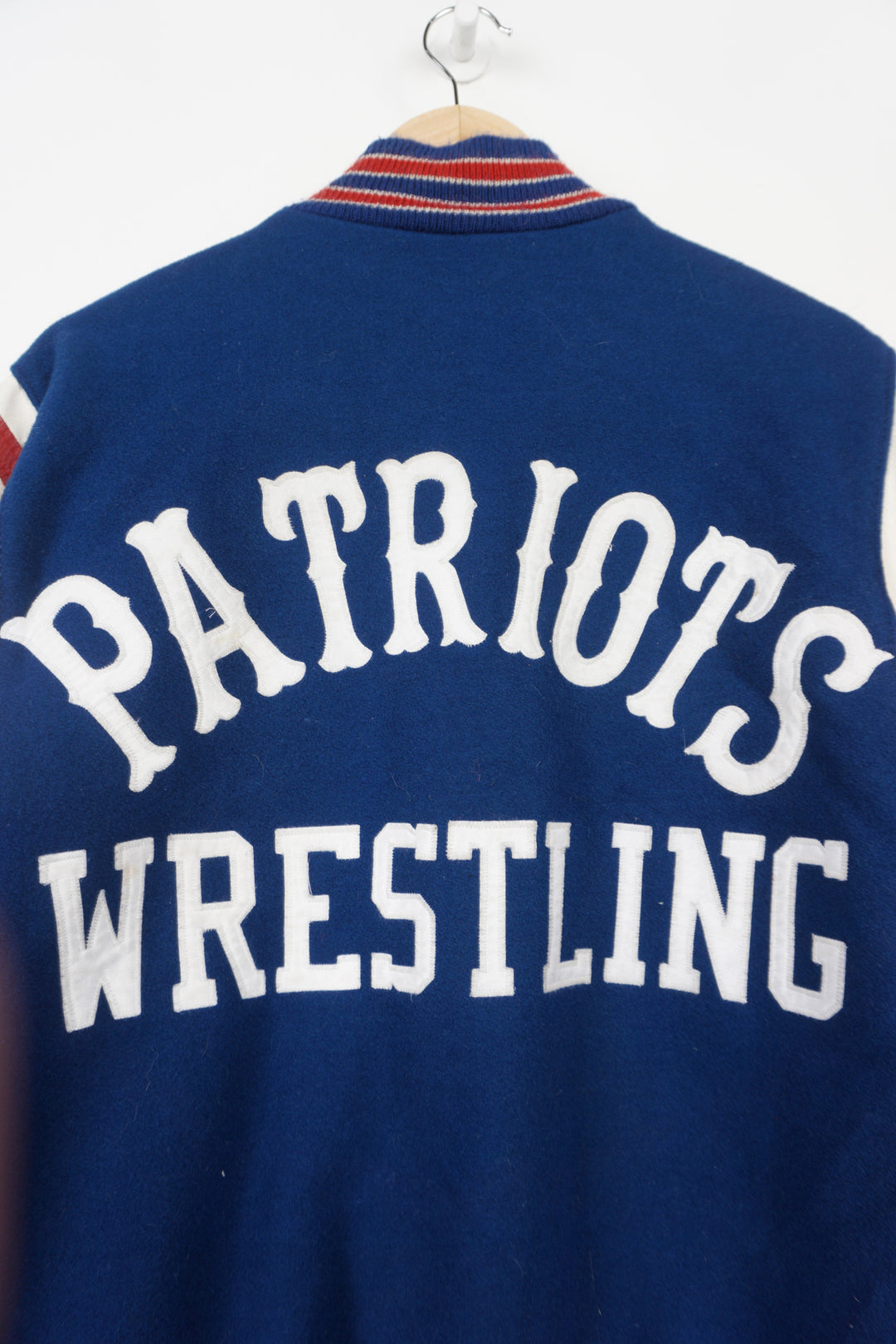 Vintage Patriots Wrestling wool varsity jacket in blue. Features embroidered details and wrestling themed pins 