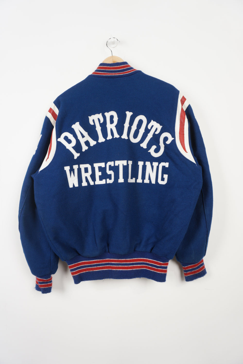 Vintage Patriots Wrestling wool varsity jacket in blue. Features embroidered details and wrestling themed pins 