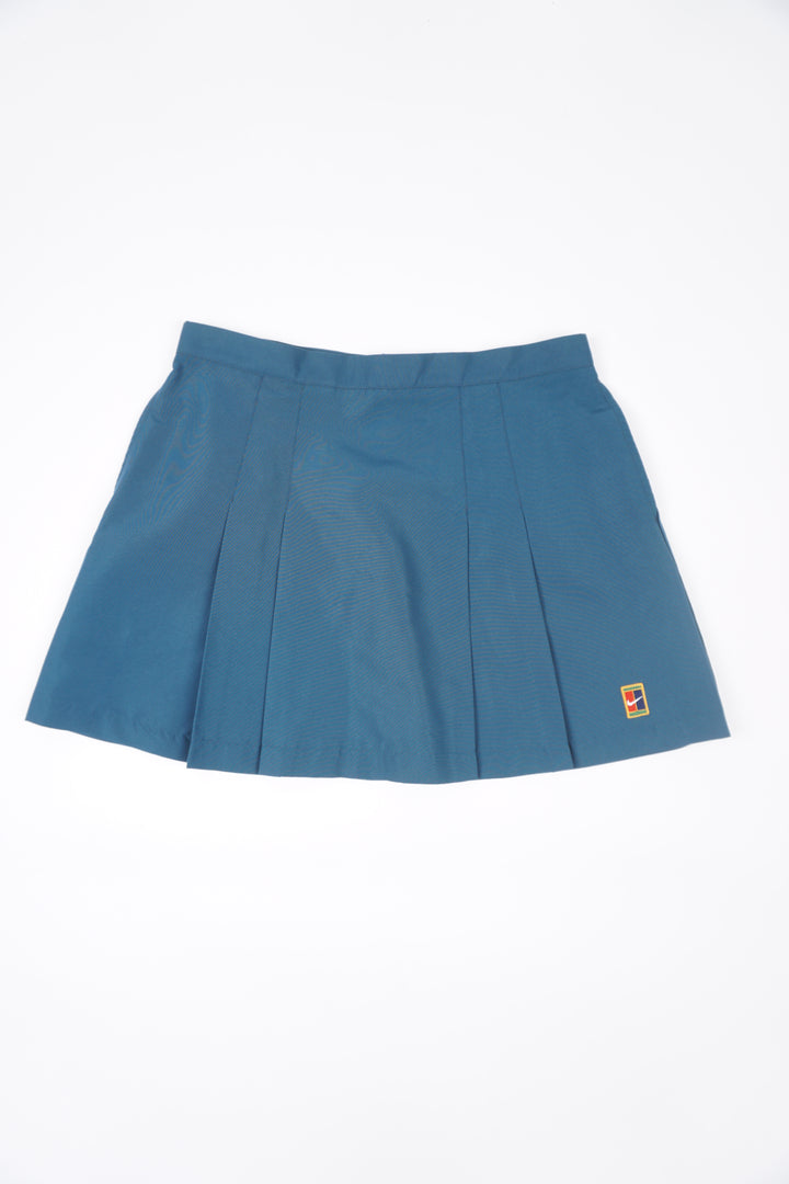 Teal blue Nike pleated tennis skirt with embroidered logo near the hem and zip closure