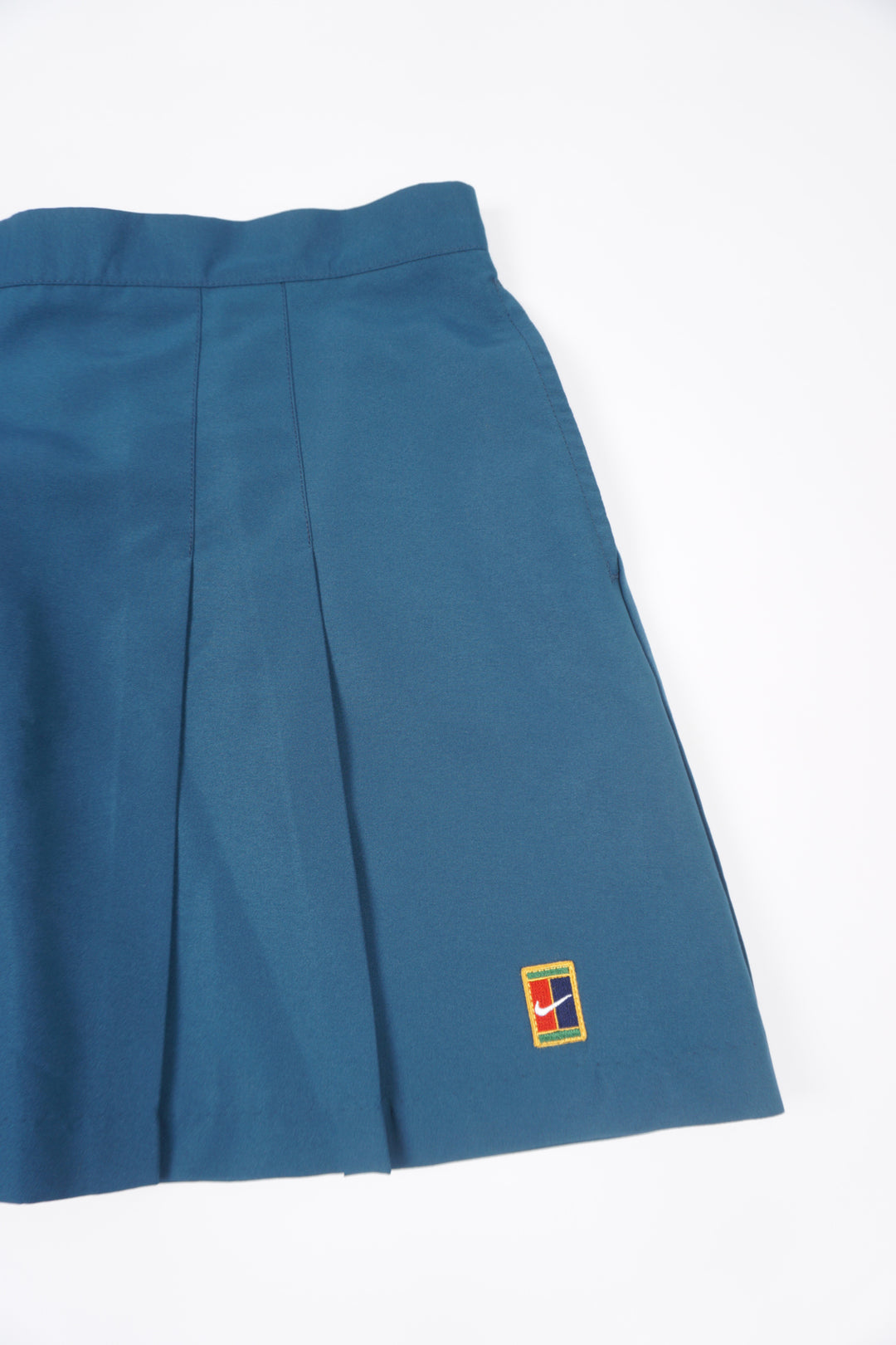 Teal blue Nike pleated tennis skirt with embroidered logo near the hem and zip closure