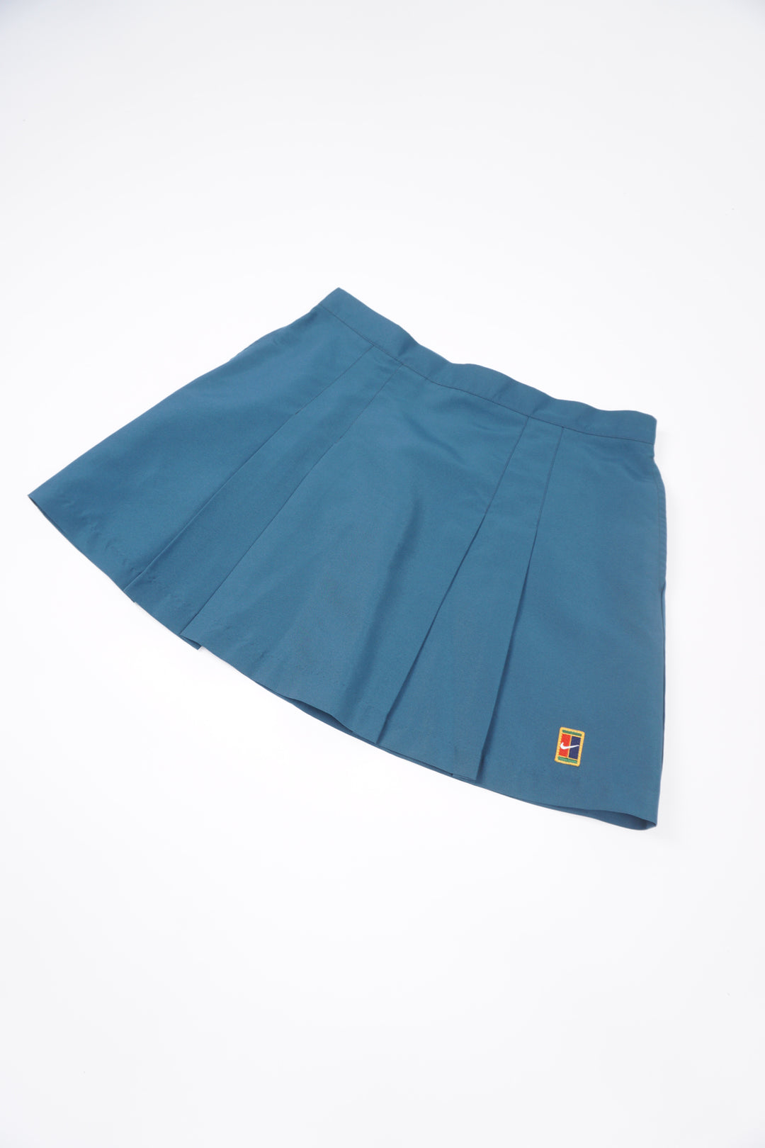 Teal blue Nike pleated tennis skirt with embroidered logo near the hem and zip closure