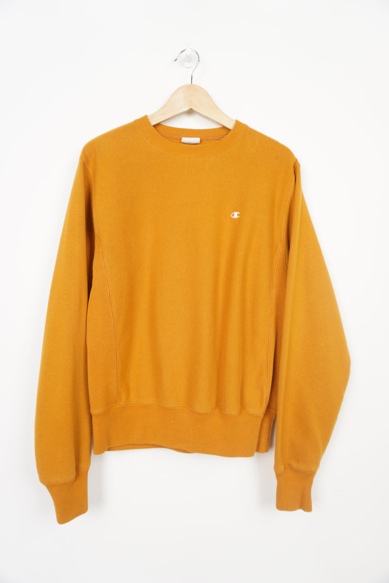 Mustard yellow crew neck Champion sweatshirt with small logo on the chest