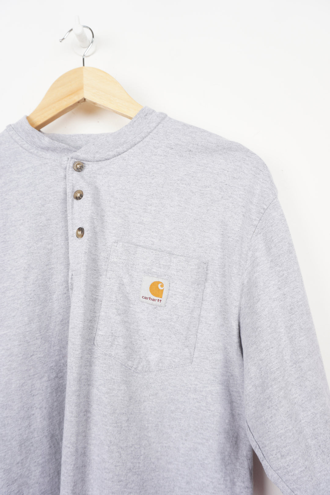 Grey long sleeve Carhartt t-shirt with branded chest pocket and button up details 