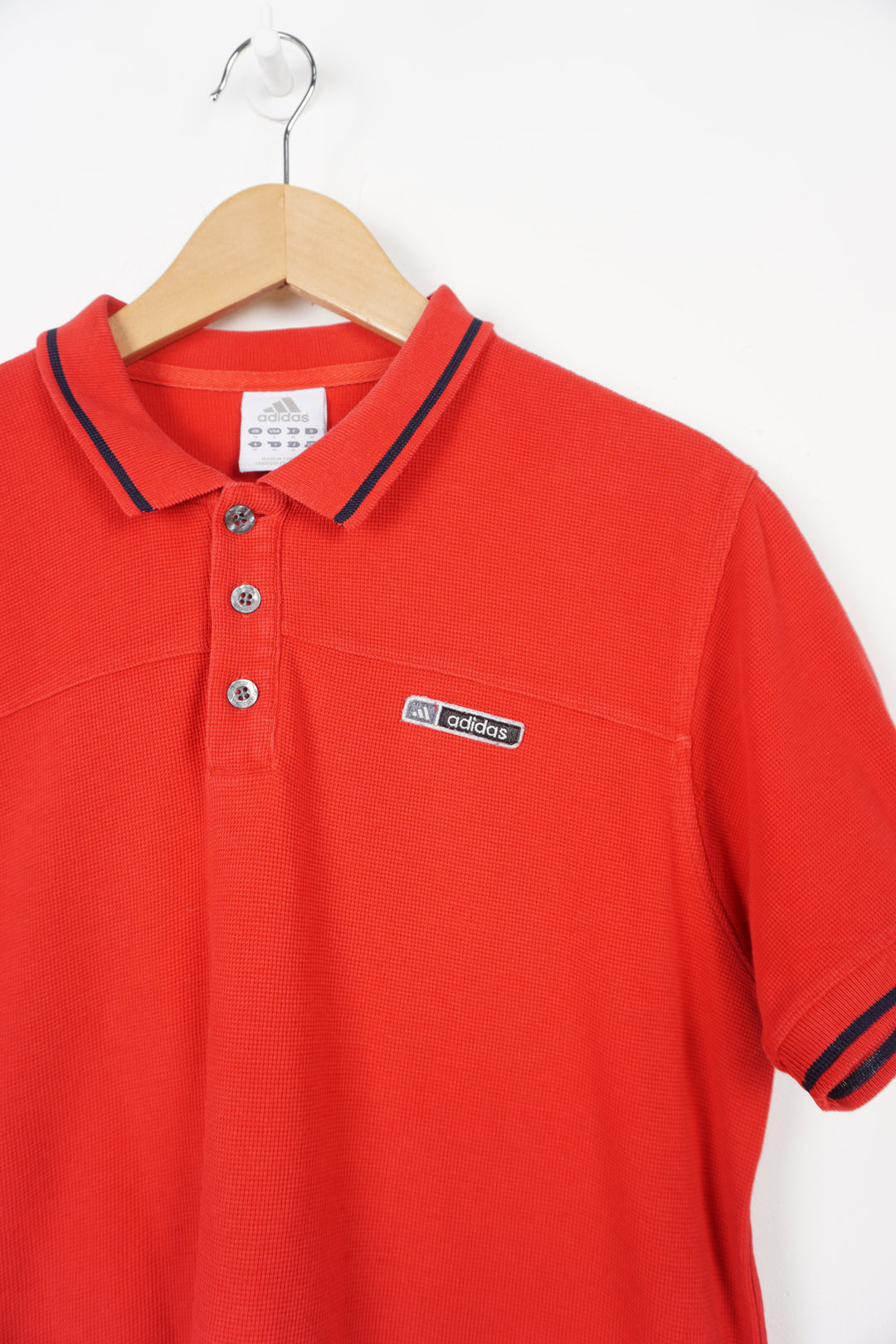 Red Adidas polo shirt with embroidered logo on the chest