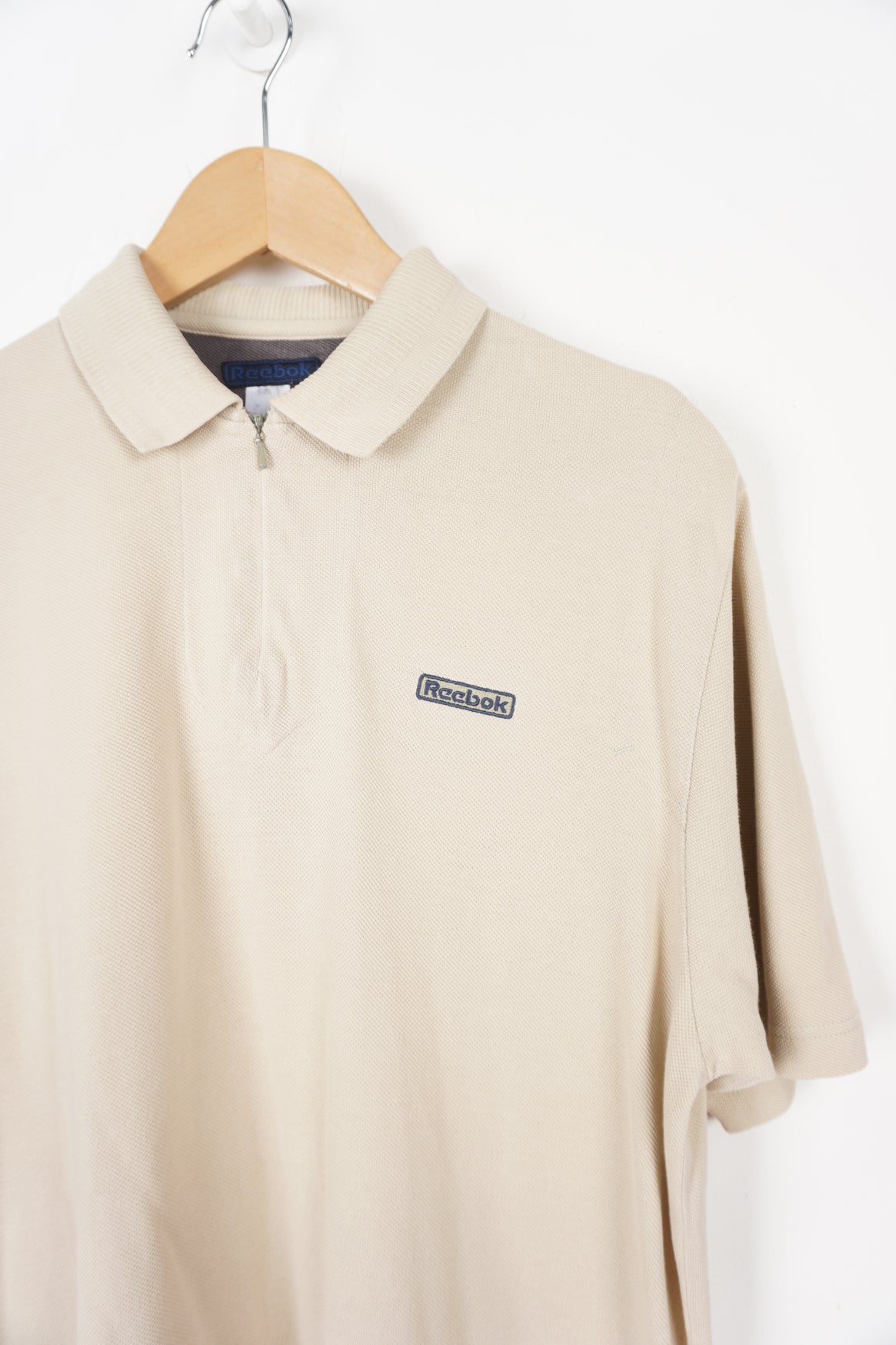 Reebok beige polo shirt with embroidered logo on the chest and 1/4 zip detail