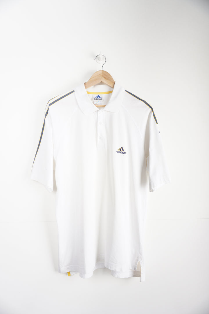 Vintage 1990s Adidas Polo Shirt with embroidered logo and grey/yellow strips down sleeves. Item in good condition, small mark on right shoulder and very small signs of yellowing around neck line Size in Label: L