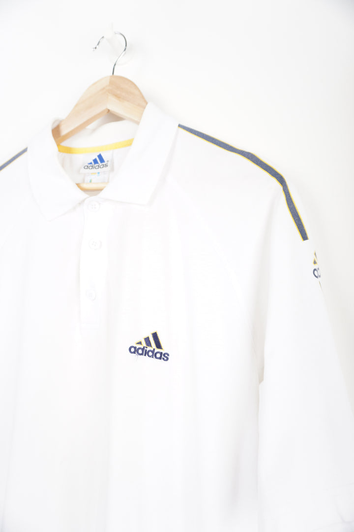 Vintage 1990s Adidas Polo Shirt with embroidered logo and grey/yellow strips down sleeves. Item in good condition, small mark on right shoulder and very small signs of yellowing around neck line Size in Label: L