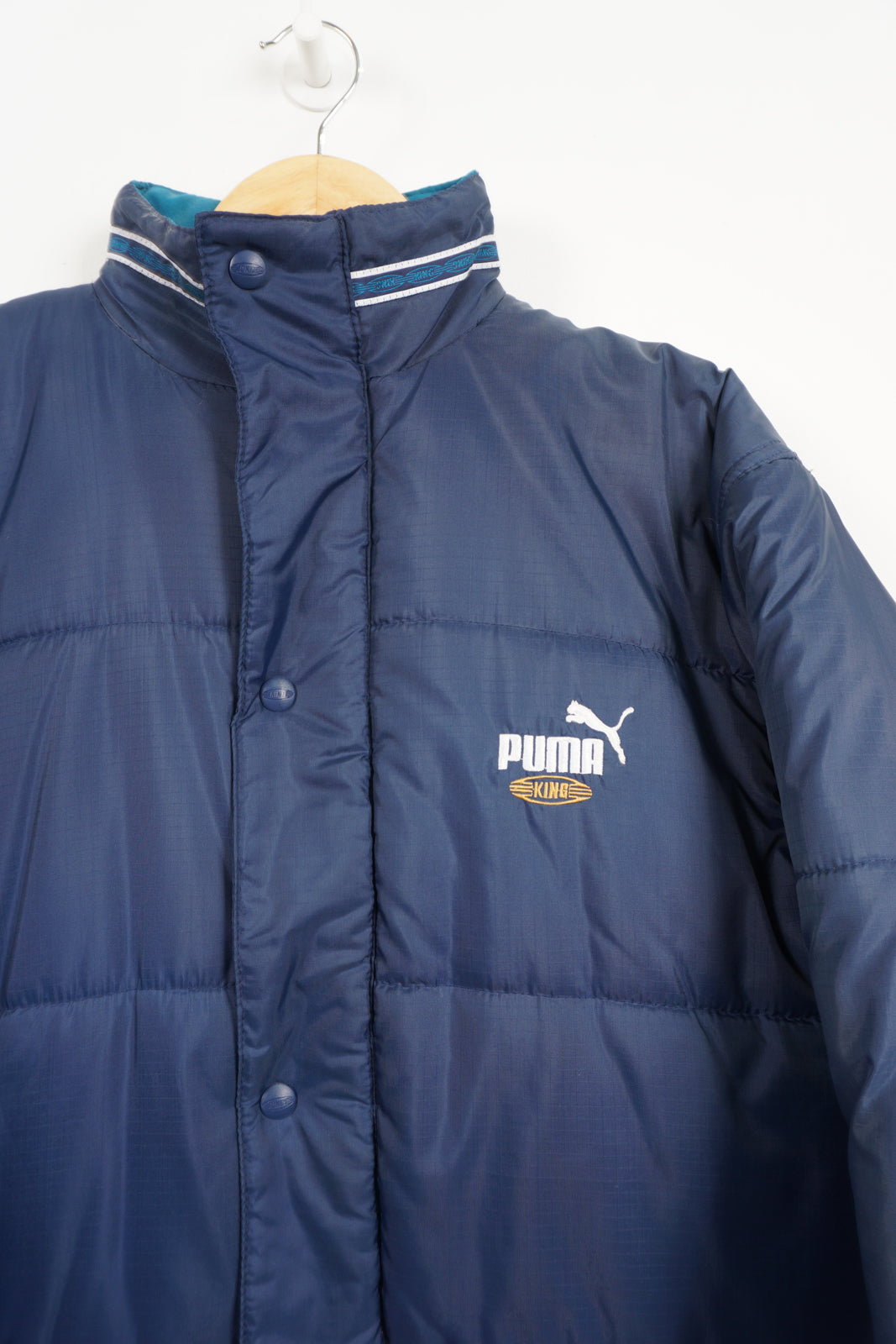 Navy blue Puma King Puffer coat with embroidered logo on the chest and foldaway hood 