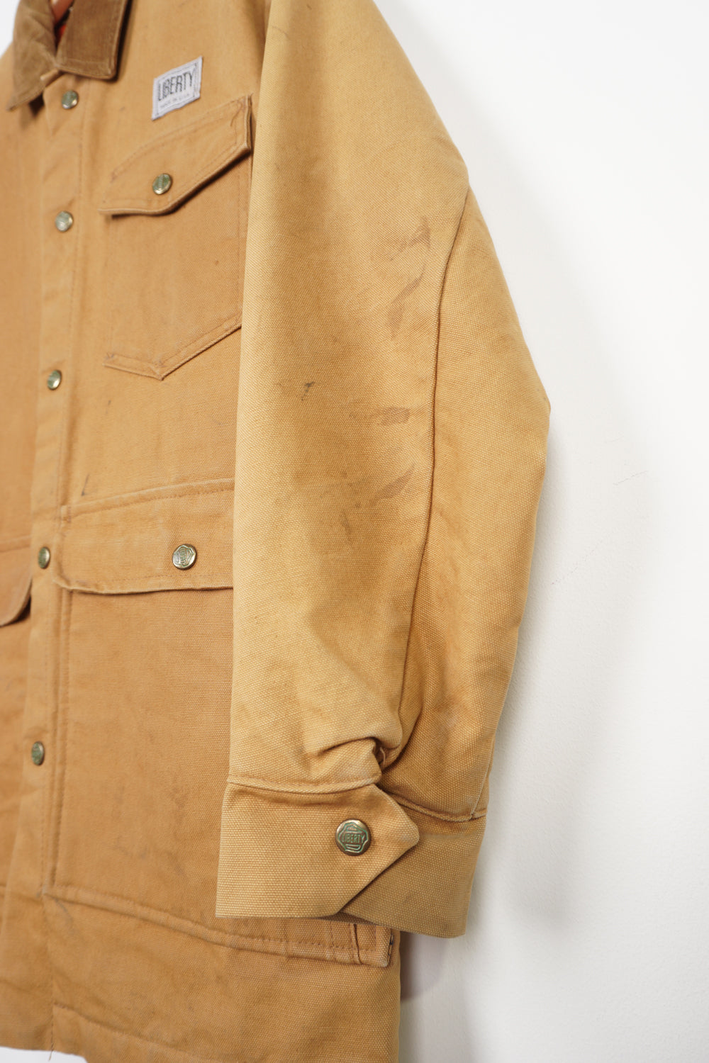 Vintage tan Liberty chore jacket with corduroy collar, multiple pockets and embroidered logo on the front