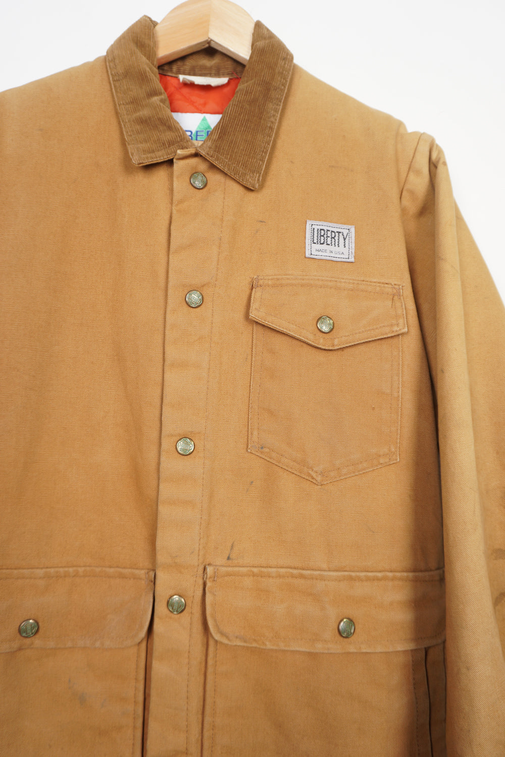 Vintage tan Liberty chore jacket with corduroy collar, multiple pockets and embroidered logo on the front