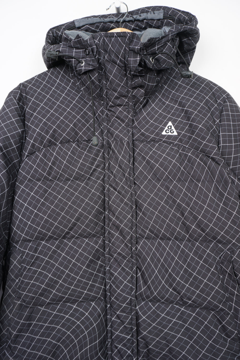 Black patterned Nike ACG puffer jacket with multiple pockets and embroidered logo on the chest