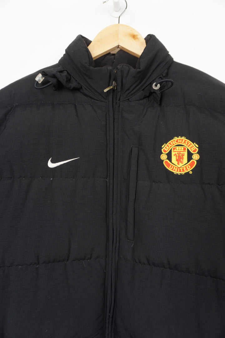 Nike Manchester United black puffer coat with embroidered badge and swoosh detail on the chest