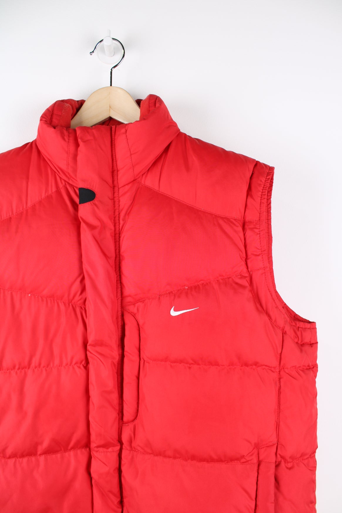 Red Nike zip through puffer gilet. Features embroidered logo on the chest.