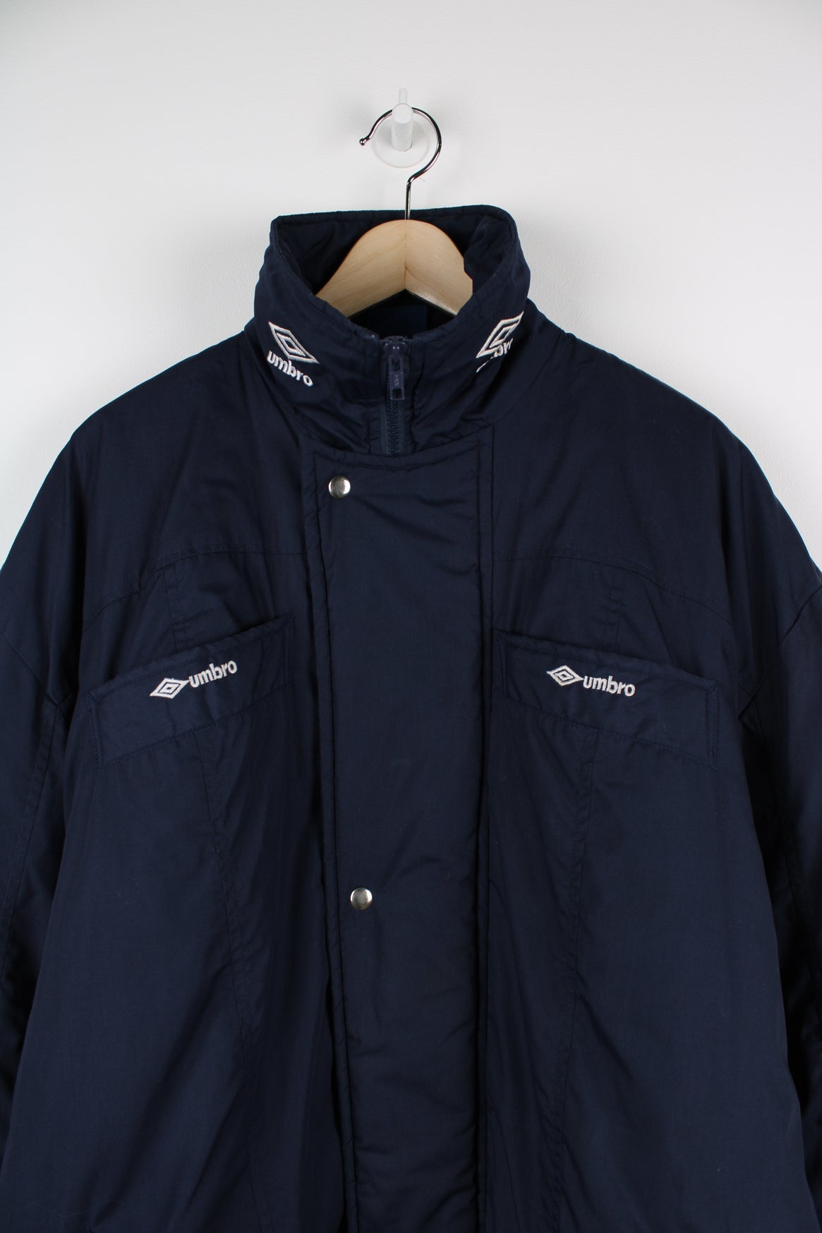 Blue Umbro maxi longline coat. Features pockets on the chest and embroidered logo on the neck.