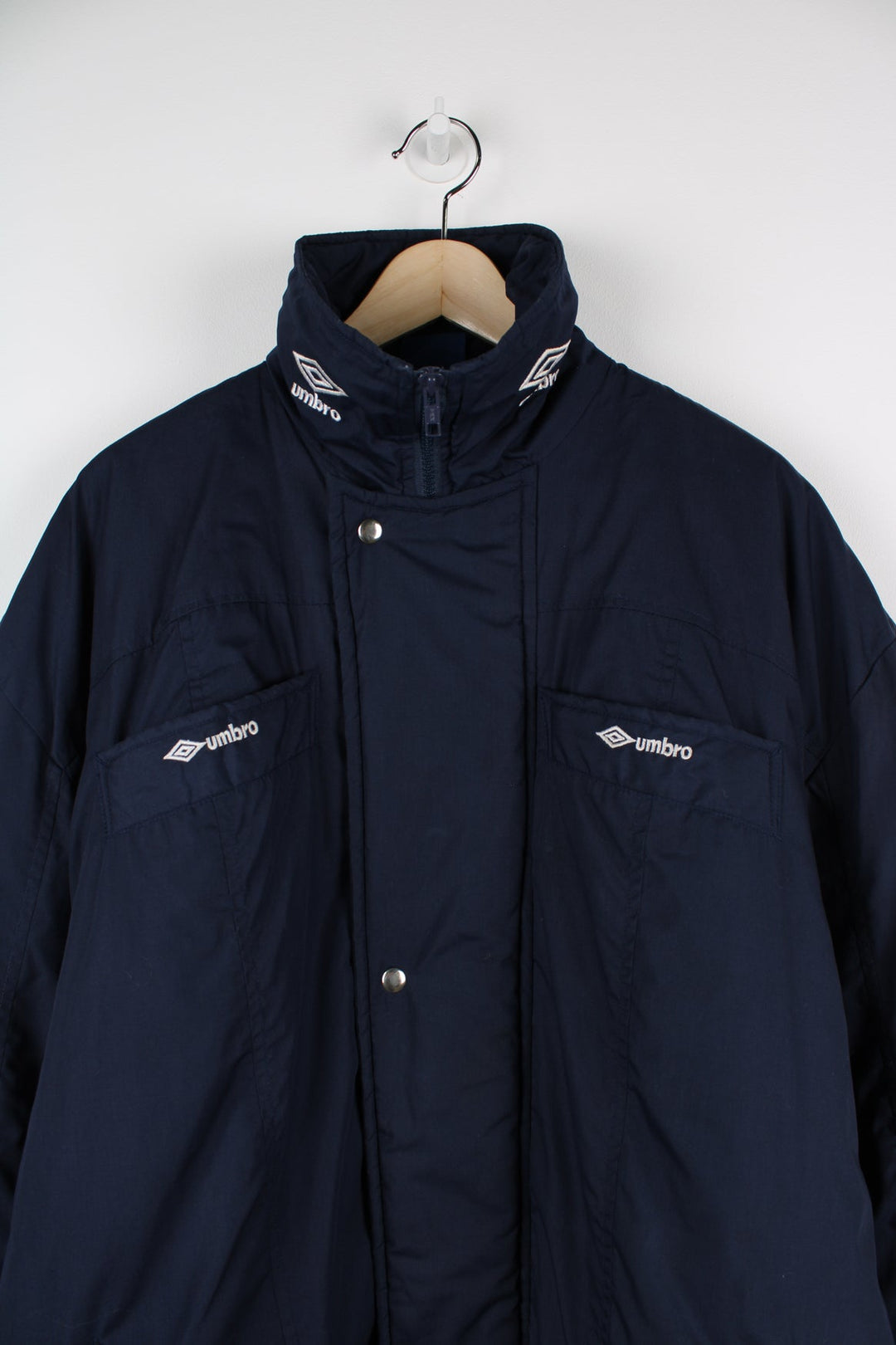 Blue Umbro maxi longline coat. Features pockets on the chest and embroidered logo on the neck.