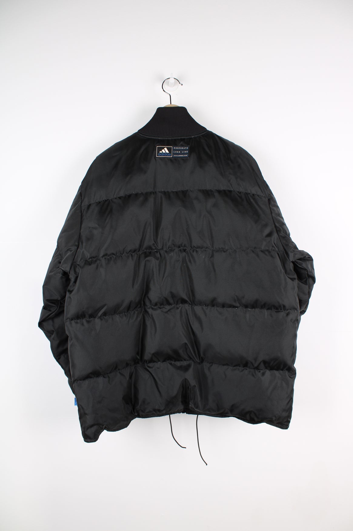 Black Adidas puffer coat with embroidered logo on the chest.