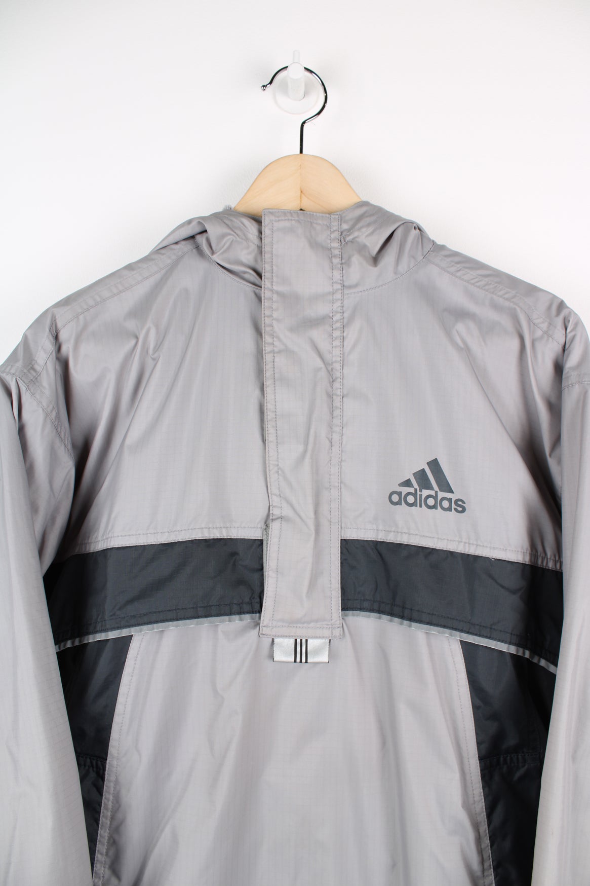 Grey and black Adidas pullover half zip jacket with fleece lining. Features printed logo on the chest.