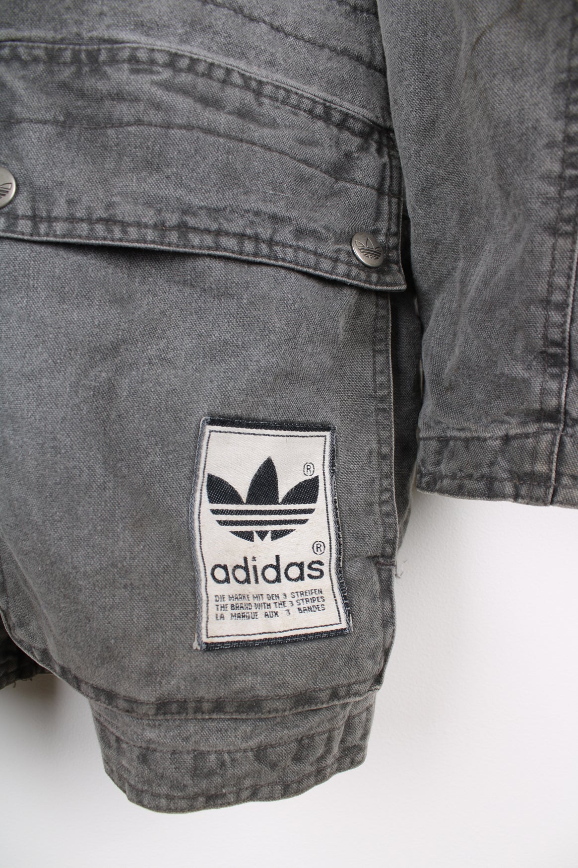 Adidas grey stonewash denim coat. Features embroidered logo on lower pocket.