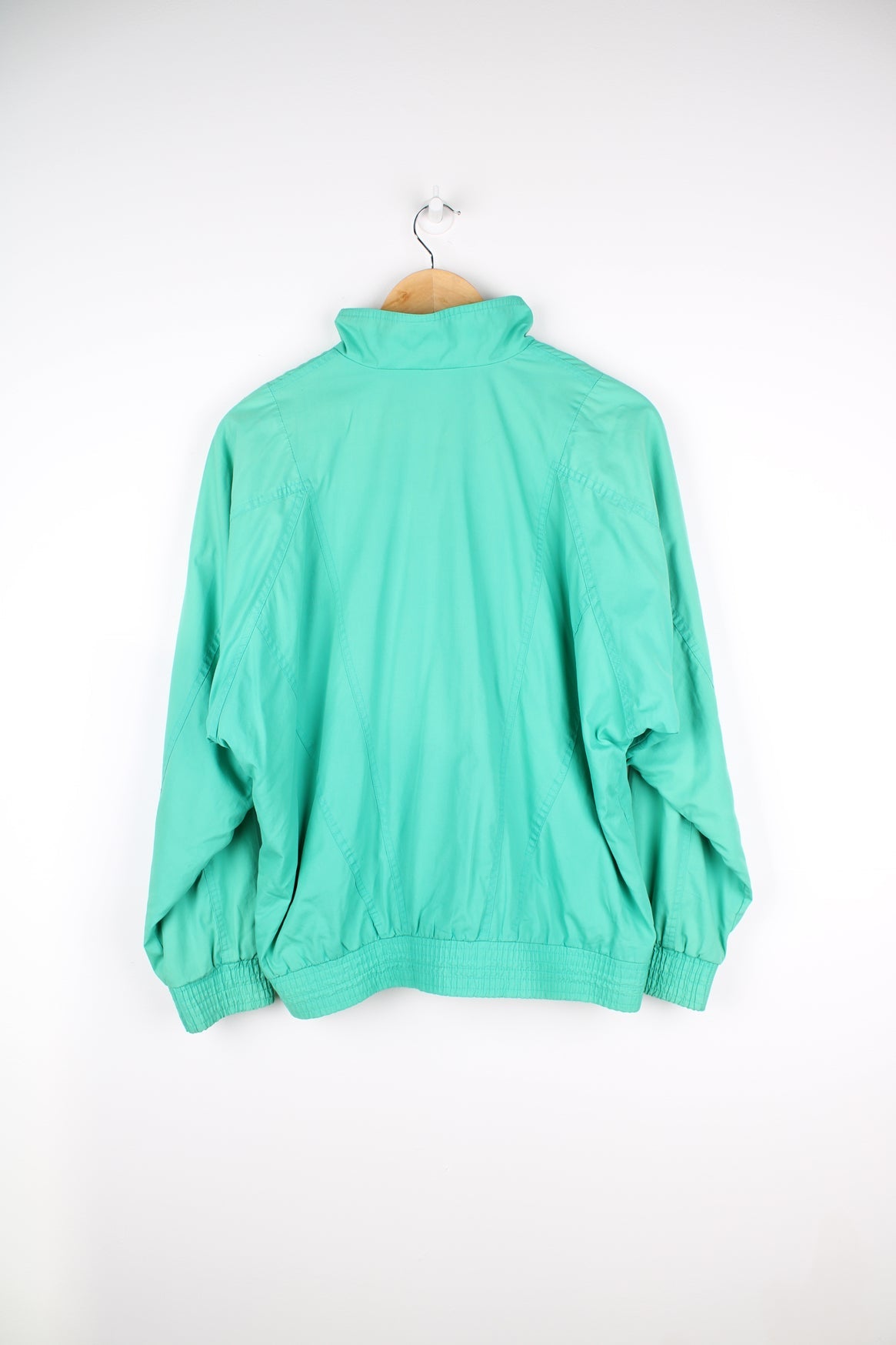 Vintage Adidas green tracksuit jacket featuring embroidered logo on the chest.