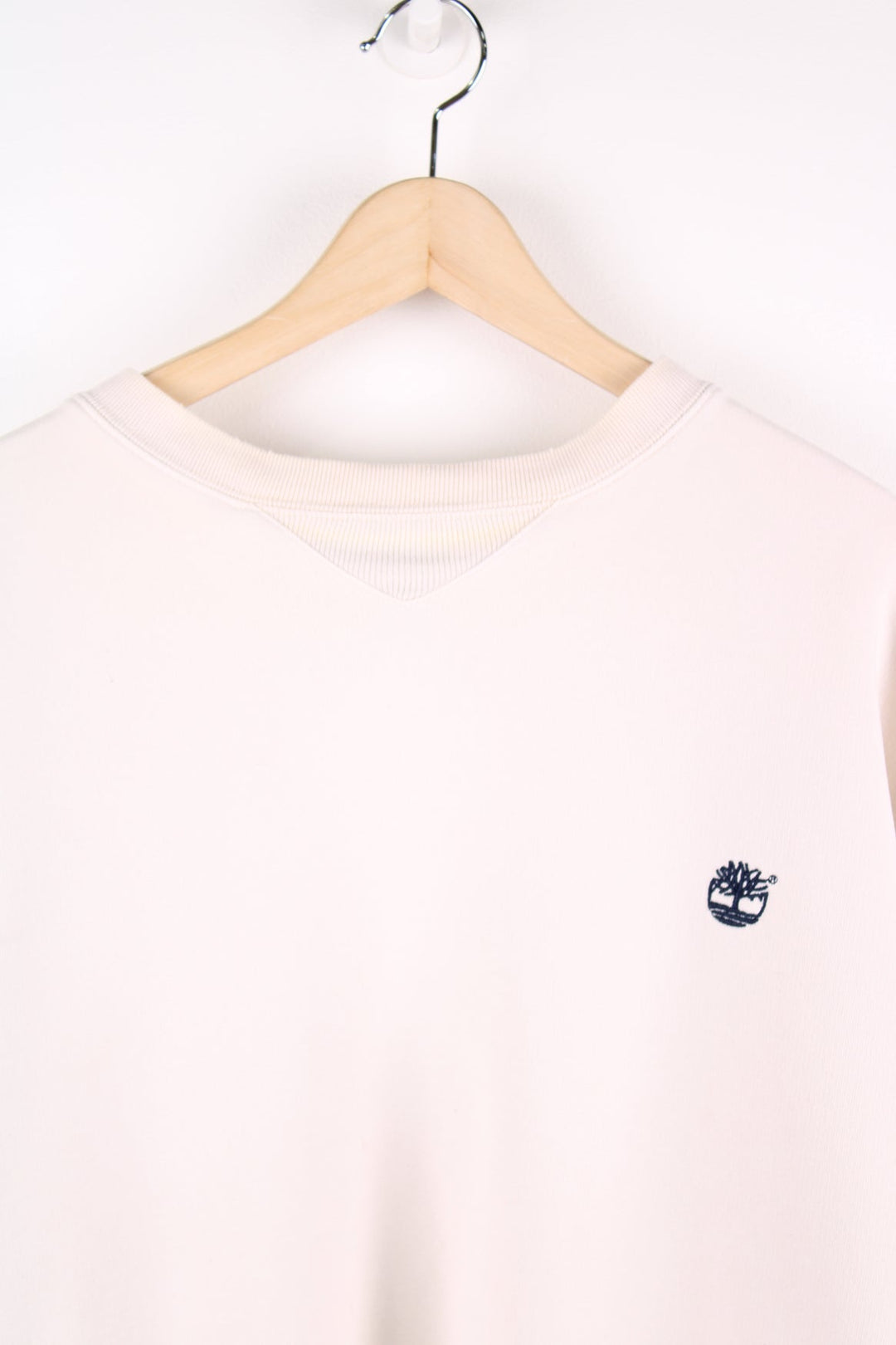 Beige Timberland sweatshirt featuring embroidered logo on the chest and sleeve.