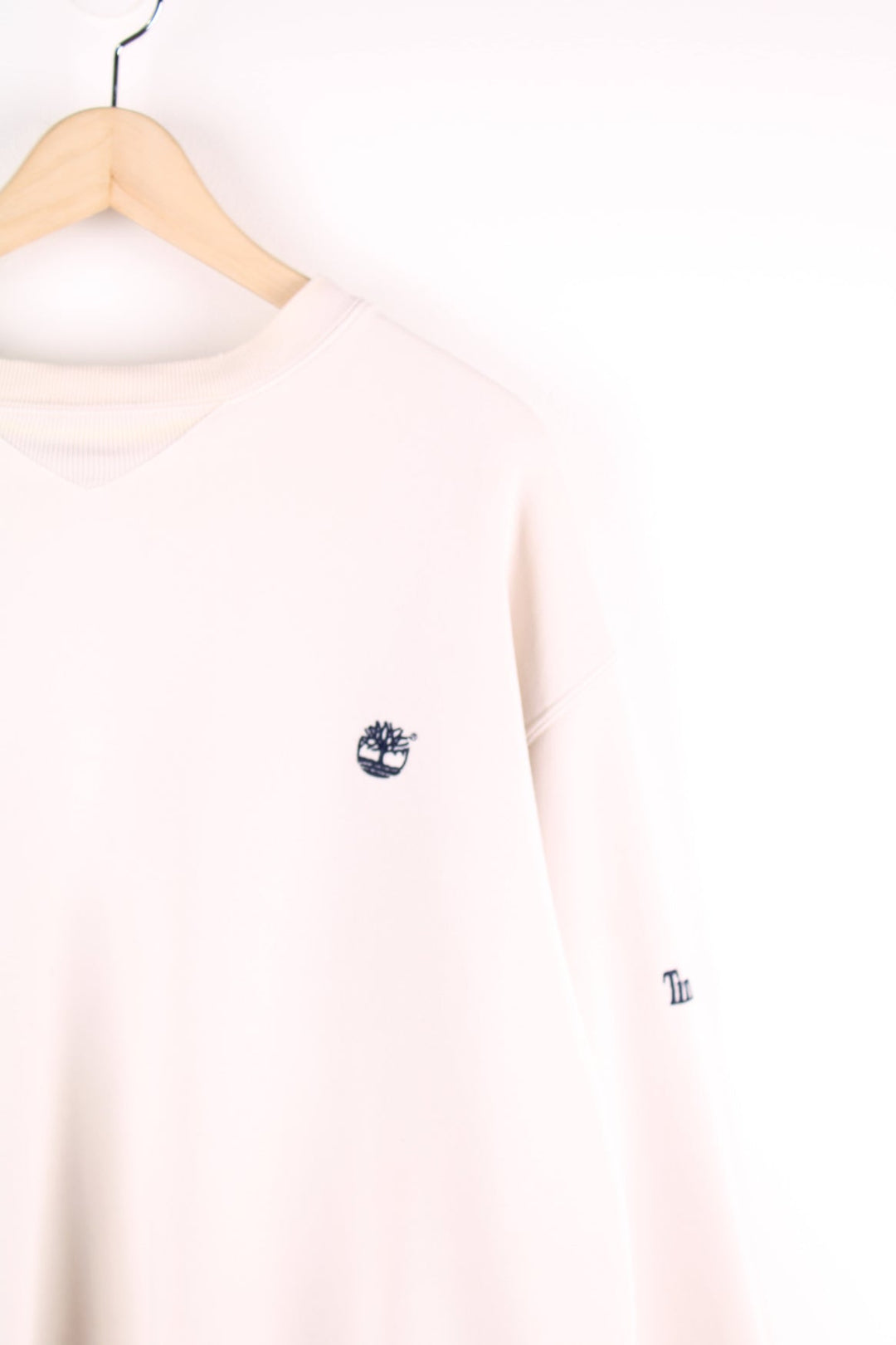 Beige Timberland sweatshirt featuring embroidered logo on the chest and sleeve.