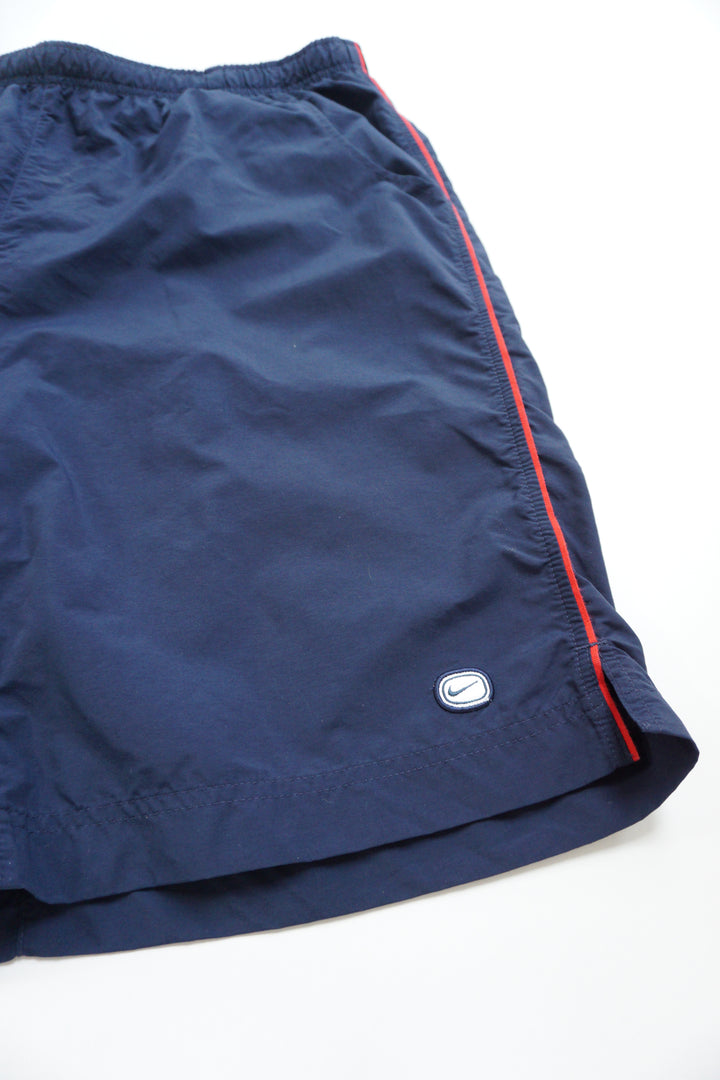 Nike navy blue swim shorts with red embroidered text on the back and mesh lining