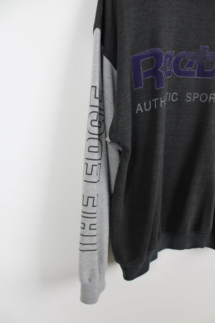 Vintage Reebok sweatshirt with printed logo across the chest in purple.